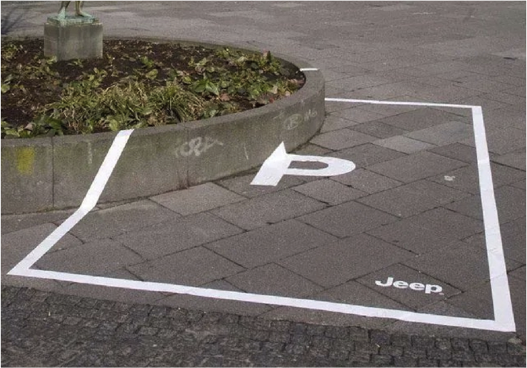 A painted parking space curves around a raised planter instead of forming a rectangle, with the Jeep logo implying the vehicle can handle obstacles with ease.